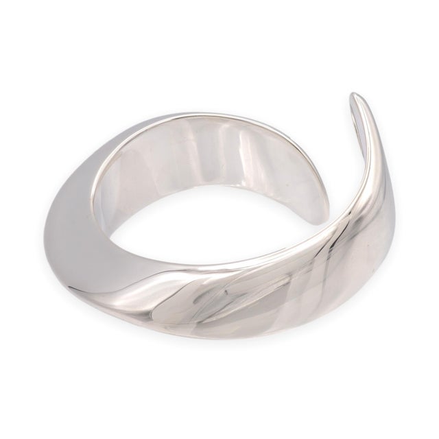 A sculptural open cuff in sterling silver from Elsa Peretti's collection for Tiffany & Co. The Swirl design features two...