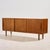 Danish teak sideboard from the 1960s with unique handles, three sliding doors and one shelf inside. The surface of the...
