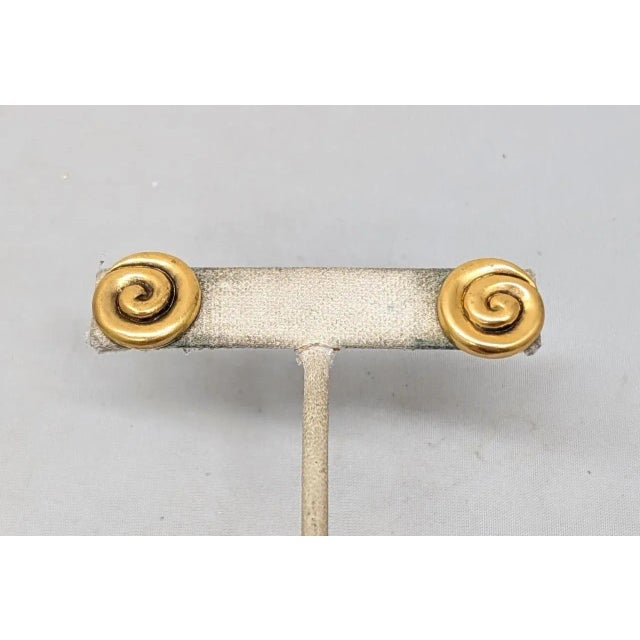 1980s small goldtone spiral push back pierced earrings. Marked "YSL©" on the backs. Measure: 5/8 inches across. Condition:...