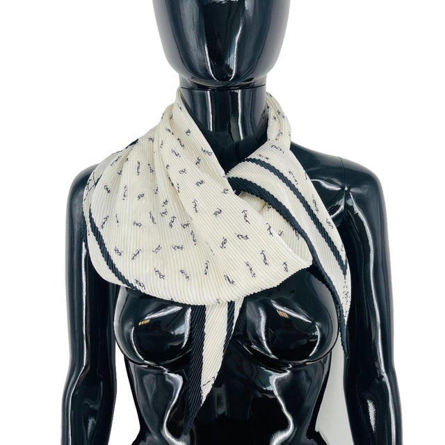 Yves Saint Laurent White Monogram Stretch Silk Scarf. Pleated (plisse) off-white square with scattered small black YSL...