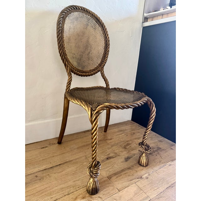 1950s - 1960s Italian gilt iron rope and tassel Hollywood Regency chair. This chair is sturdy and well made. It is in the...