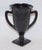 Black amethyst glass vase in the form of a loving cup made by L. E. Smith, c. 1930's. Features dancing classical figures
