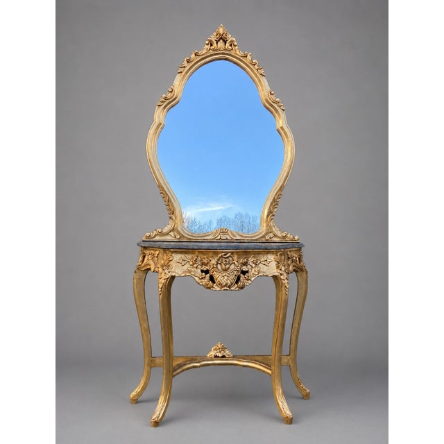 This elegant French console table and matching mirror date to approximately 1920. Artisan-made from solid carved...