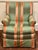 A generously proportioned upholstered club chair in a striking striped textile of soft green, coral and muted gold. The...