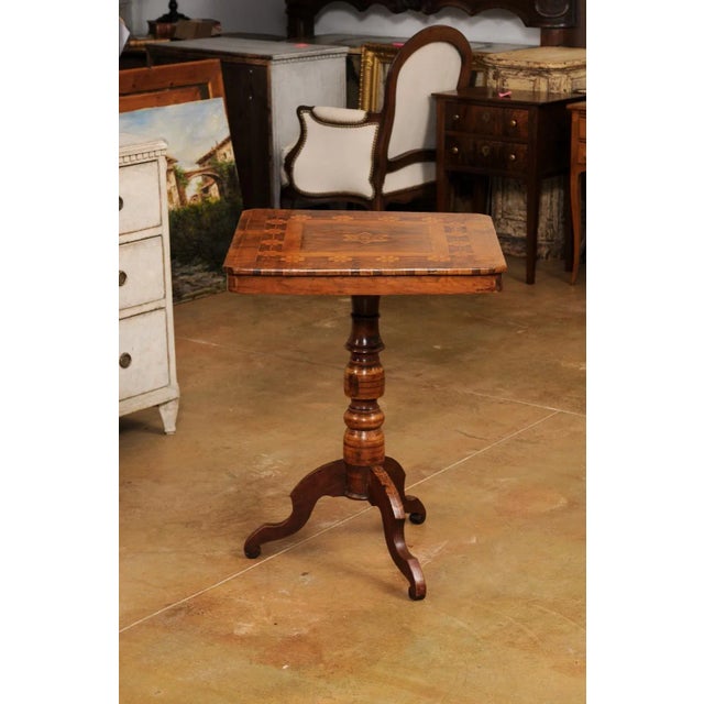 An Italian walnut, mahogany and European birch center table from the 19th century, with geometric and star shaped...