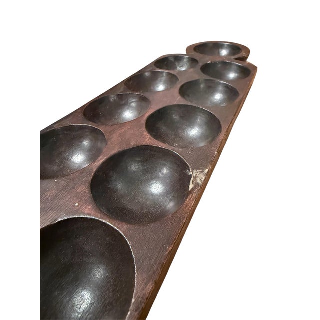 A vintage mancala game board. Hand-carved with a beautiful patina, functional as a tray or an accent piece on your dining...
