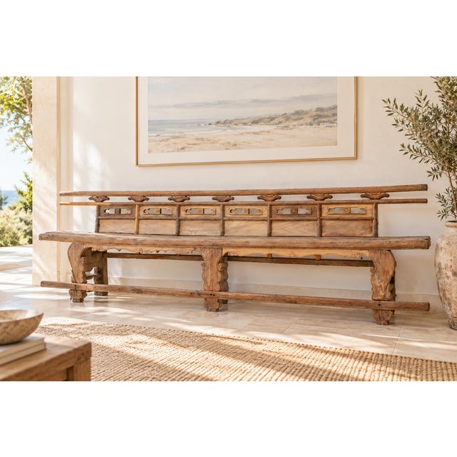 A single thick plank of elm runs nearly ten feet, rising to a pierced and carved back where six openwork panels, each...