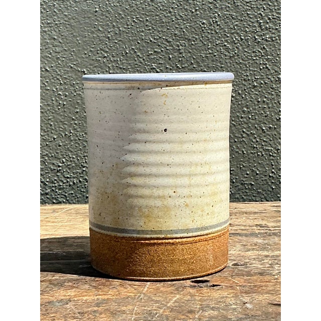 This vintage studio pottery vase exhibits a sophisticated blend of minimalist form and organic texture. Hand-thrown from a...
