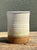 This vintage studio pottery vase exhibits a sophisticated blend of minimalist form and organic texture. Hand-thrown from a...