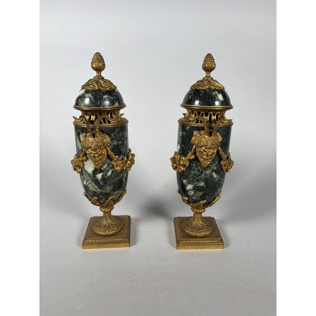 Pair of Louis XVI style green marble and gilt bronze cassolettes. The marble cassolettes are richly decorated with two...