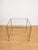 Elegant vintage Italian-made side table dating back to the 1960s, featuring a geometric polished brass frame with double...