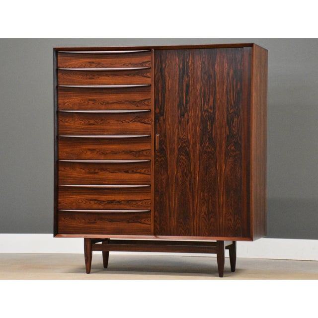 A mid century modern rosewood armoire dresser with seventeen drawers and sliding tambour door designed by Svend Age Madsen...