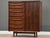 A mid century modern rosewood armoire dresser with seventeen drawers and sliding tambour door designed by Svend Age Madsen...