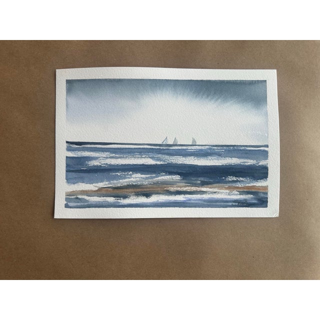 A minimalist seascape rendered in layered blue-gray washes, capturing the rhythmic movement of waves beneath an expansive...
