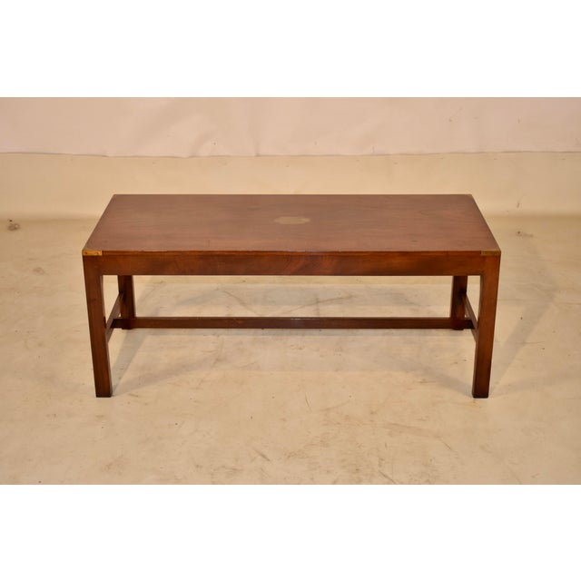 English Campaign style coffee table from England. This table is made from mahogany and banded in brass, circa 1960. The...
