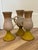These mid-century style stoneware goblets feature a distinct tri-color glaze with a yellow pedestal base, a light grey or...