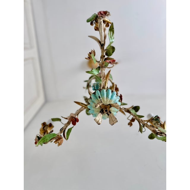 Rare 1950s Italian Florentine three-light chandelier crafted from painted and gilt tole iron with an elaborate arrangement...