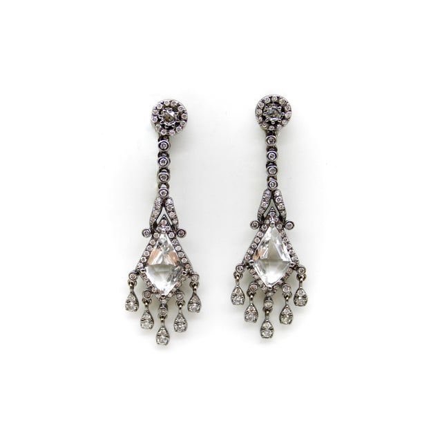These 18k gold earrings are beautifully designed with the utmost creativity. The design is focused around a large lozenge-...