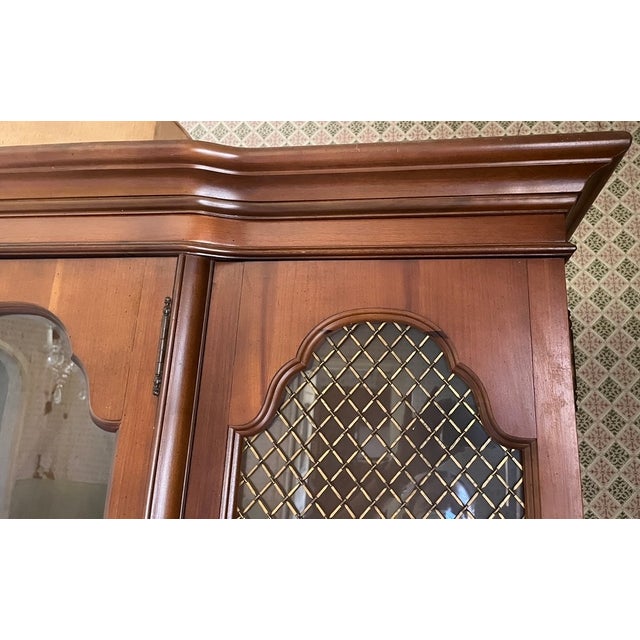A substantial French Provincial-style china cabinet by Style House, comprising a two-piece construction — a display hutch...