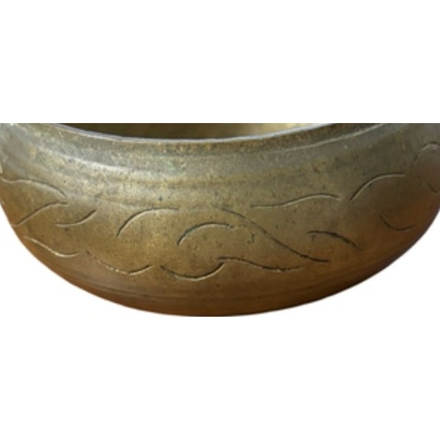 Likely made in India in the mid-20th century, this beautiful vintage brass bowl reflects traditional metalworking...
