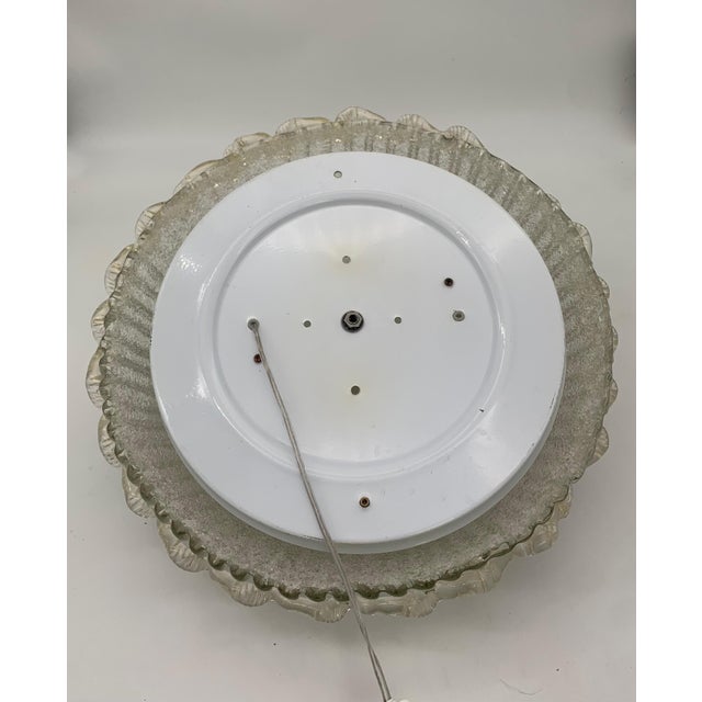 Ceiling lamp, a highly decorative glass fixture featuring a rounded, curved shape with a textured surface reminiscent of...