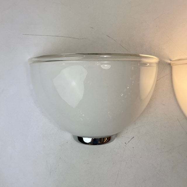Set of two sconces in white murano glass with a clear edging and a chromed metal base. Designed liciano vistosi for...