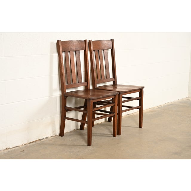 A gorgeous pair of antique Mission or Arts & Crafts period quarter sawn oak slat back side chairs or dining chairs In the...