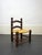 Low fireplace chair in turned wood with a rush seat. A mid-20th-century French handcrafted piece in the style of French...