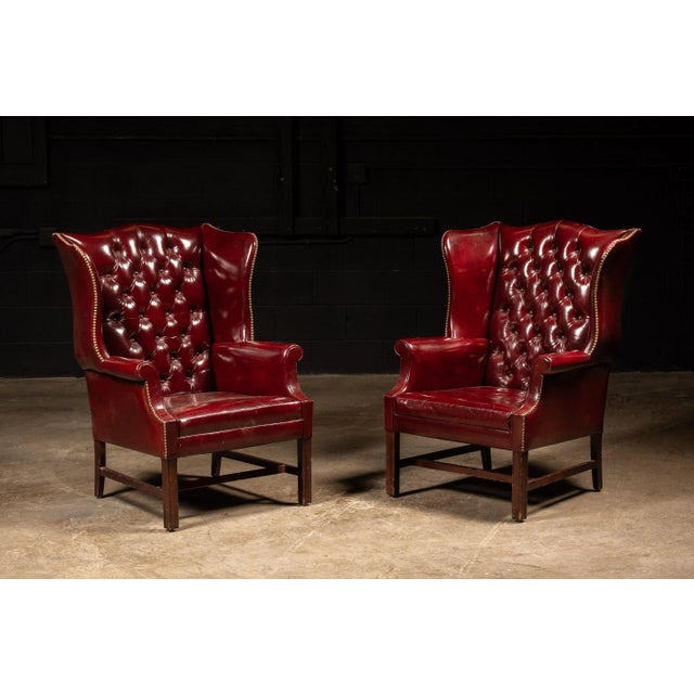 Vintaged wingback arm chair with a brass nailhead trim. This piece features a deep, rich shade of red that retains high...