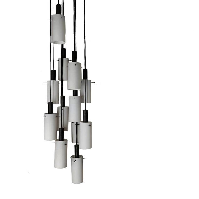 Vintage 60s cascade suspended chandelier with 12 individual black/white pendant lights hanging from a circular ceiling...