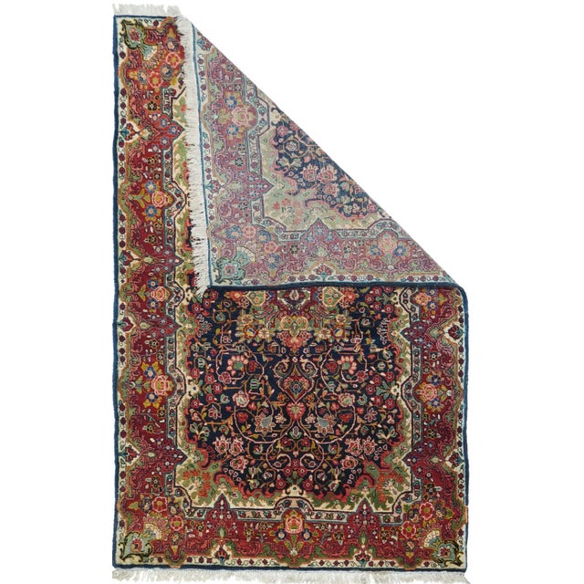 This vintage, west Persian rustic scatter features a notched and flaming rectangular navy sub-field with a four palmette...