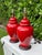 Striking vintage pair of ceramic table lamps featuring classic covered-jar forms finished in a vibrant glossy red crackle...