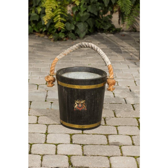 An English Champaign bucket made of oak with copper bands and a coat of arms from the late 19th century. This oak bucket...