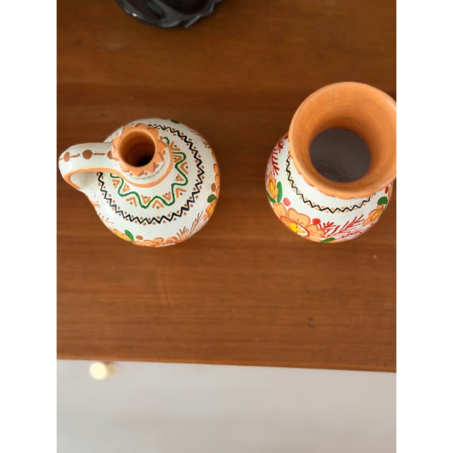 A set of two pieces of Eastern European vessels: a small jug and a small bud vase created by Katarína Ďurišová in the town...