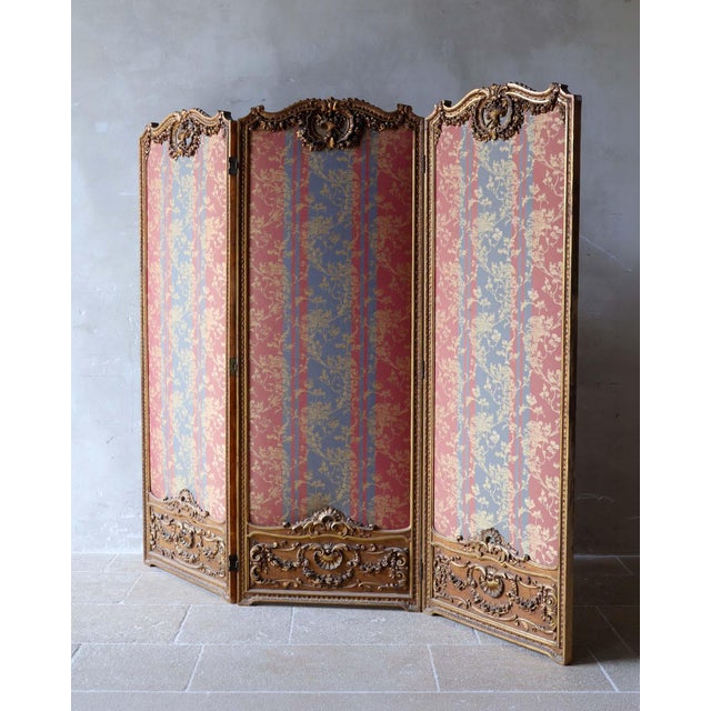 Antique 19th century three panel room divider in gilt and carved wood. This eclectic piece harmoniously combines the...
