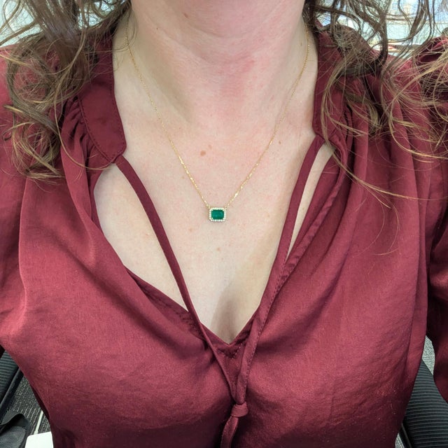 1.7ct Zambian emerald pendant (8×6mm) framed by a brilliant natural diamond halo, crafted in solid 14K gold. Comes with an...