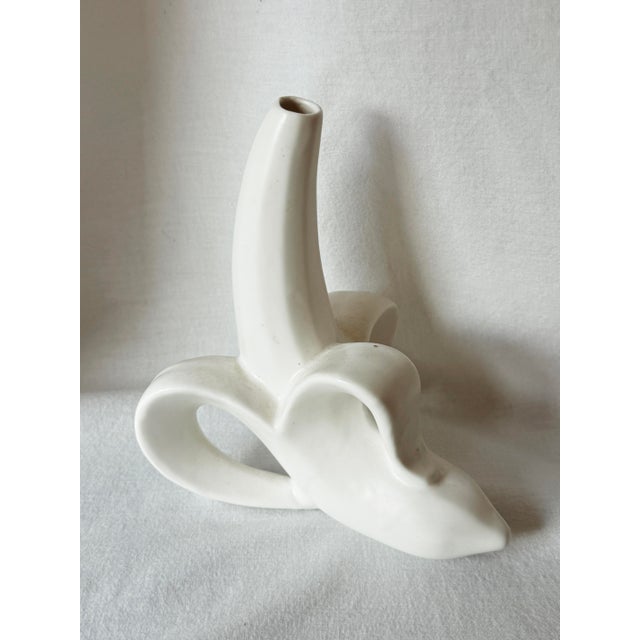 Y2K white ceramic banana bud vase attributed to Jonathan Adler, featuring a playful partially peeled design that reveals...