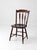 A vintage Windsor style side chair featuring a sculpted seat, spindle back, tapered turned legs, and softly arched crest...