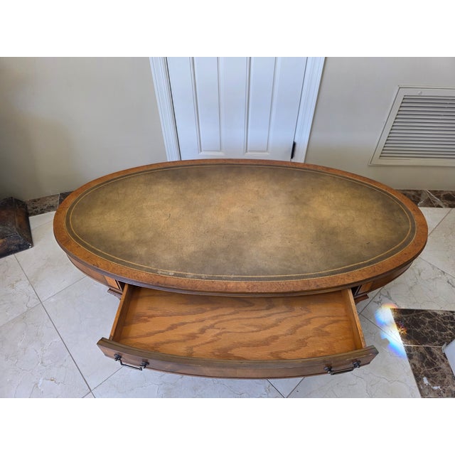 Offered is a classic mid-century oval coffee table from the prestigious "Heirloom Quality" collection by Weiman Furniture....