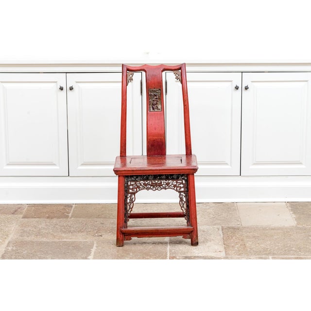 A late 19th century Chinese red lacquered and gilt wedding or bride’s chair with a plank seat, curved back splat and...
