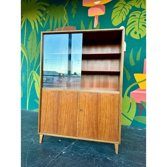 Mahogany Mid Century Modern German China Hutch Display Cabinet c.1950’s. Upper section features two wood shelves behind...