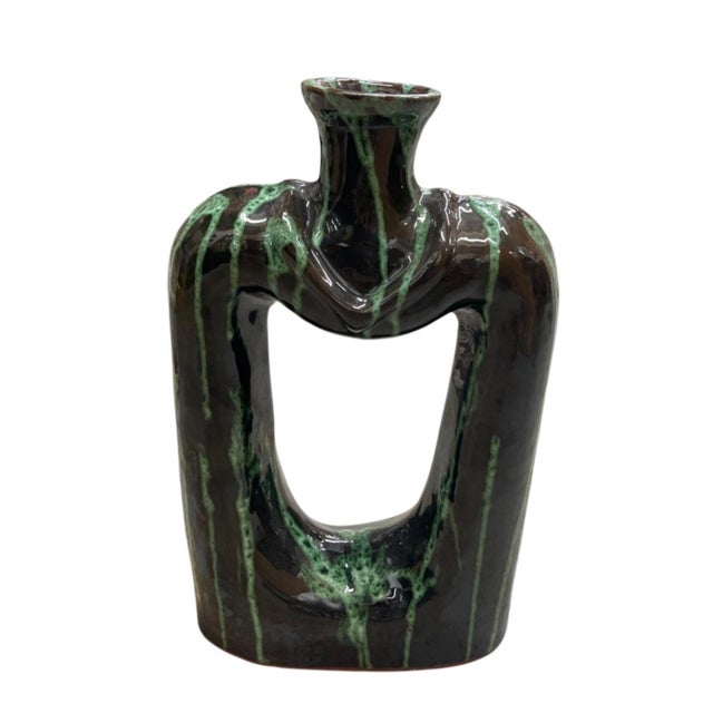 This striking mid-century modern ceramic vase blends architectural form with a rich, organic glazed finish. Defined by a...