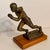 1950’s track and field trophy shows a male athlete in mid-stride leaning forward running with determination. It is made of...