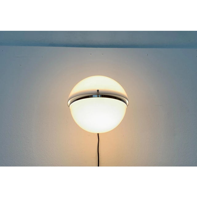 Sphere wall lamp by Guzzini based on a design by Luigi Bandini Buti for Kartell. The two halves of the plastic diffuser...