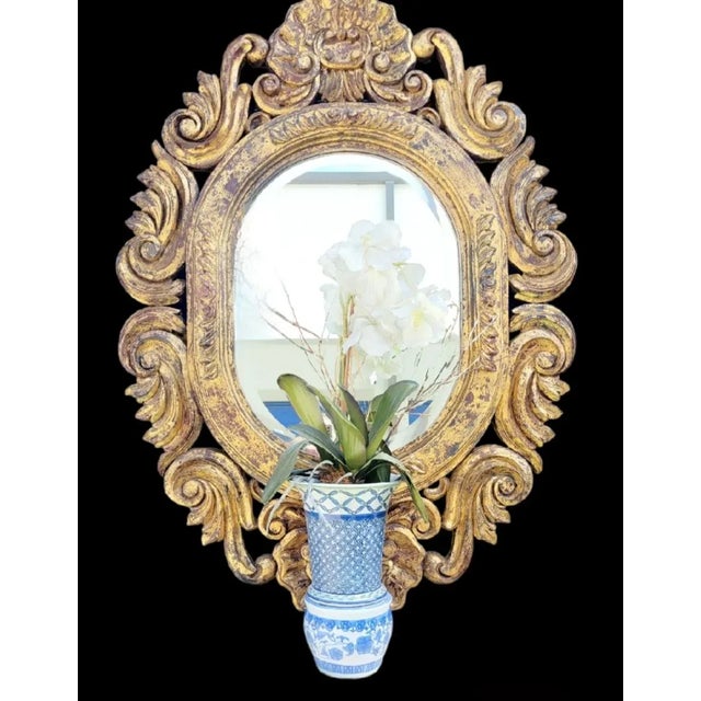 An incredible solid wood carved with gold gilt oval wall mirror. The mirror is very heavy with gorgeous gold leaf gilt and...
