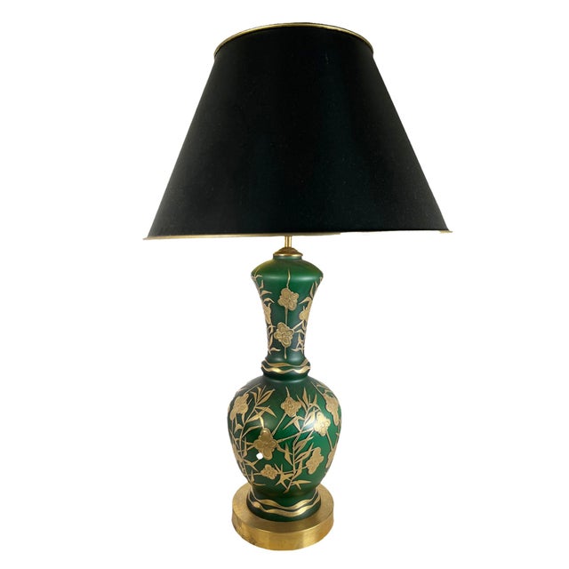 A pair of green frosted glass lamps with black shades and raised gold decoration of flowers and vines. Circa 1890, France.