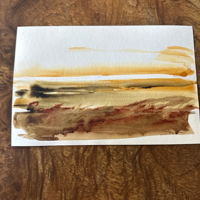 Warm, horizontal washes of honey and bronze suggest a late-afternoon shoreline or open field at sunset. Loose, wet-on-wet...