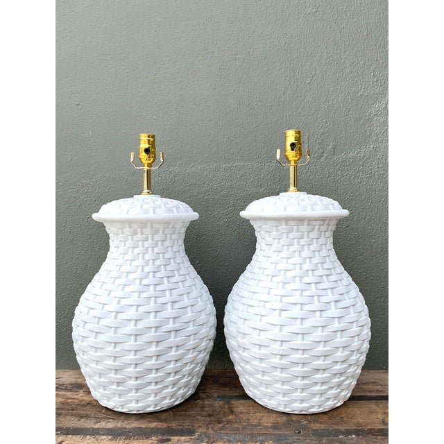 This exquisite pair of vintage table lamps masterfully mimics the organic texture of hand-woven rattan through the medium...