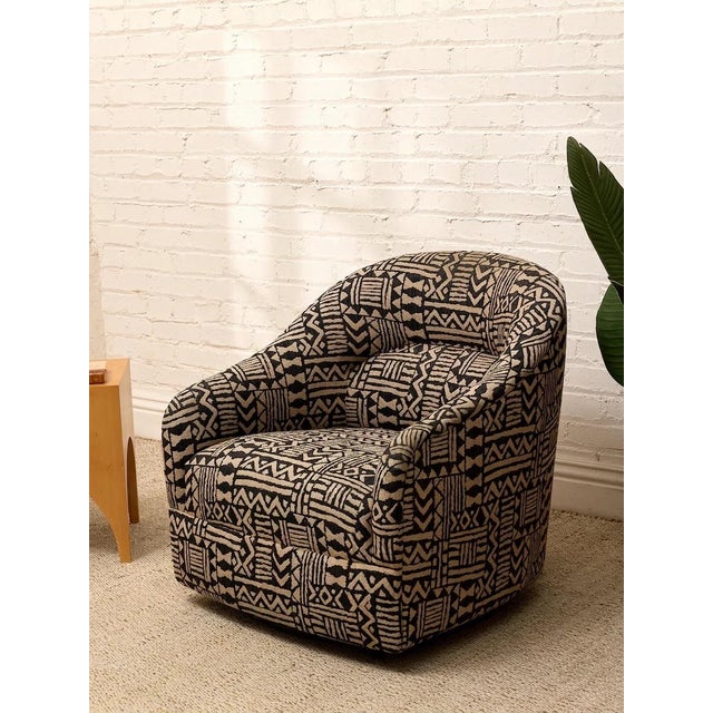 A bold vintage postmodern club chair with a rounded, enveloping silhouette and graphic black-and-tan upholstery. The...