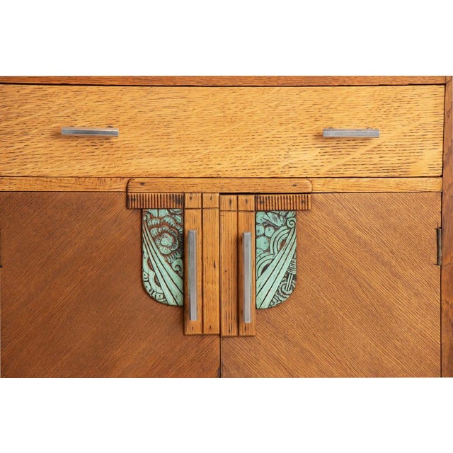An art deco oak sideboard with striking stepped detailing, c1930. The symmetrical form features two central drawers over...